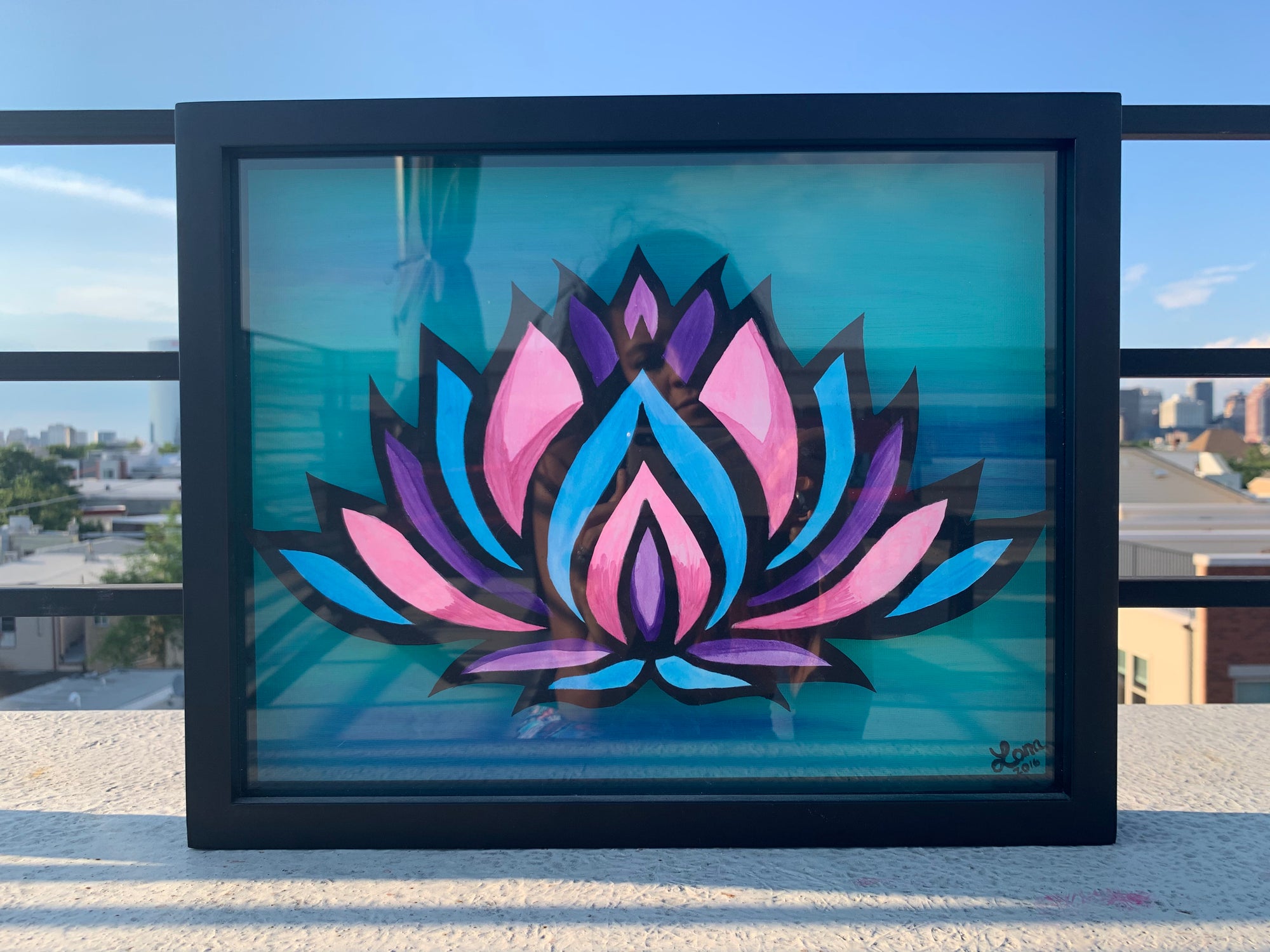 Colorful lotus flower on watercolor paper in a shadow box with green acrylic background